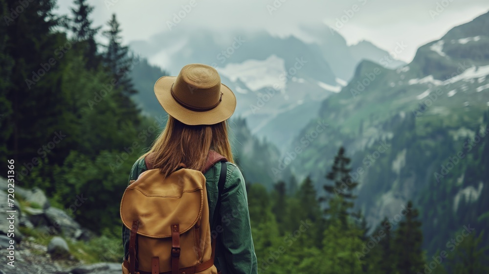 A woman traveler hiking in the mountains, captivated by the awe-inspiring beauty of nature.