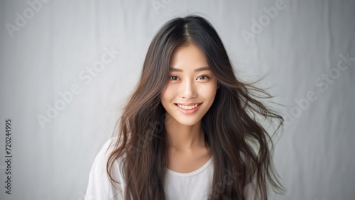 pretty Asian girl showcases flawless skin and flowing long hair in a striking photo, set against a pristine white background for a timeless and clean look. Generative AI. © Surachetsh