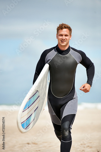 Photography Surfer, man with surfboard and run on beach for extreme sports, wet suit and adventure in the sun