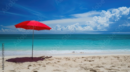 A picturesque beach scene with a vibrant red parasol  soft white sand  and crystal blue waters.