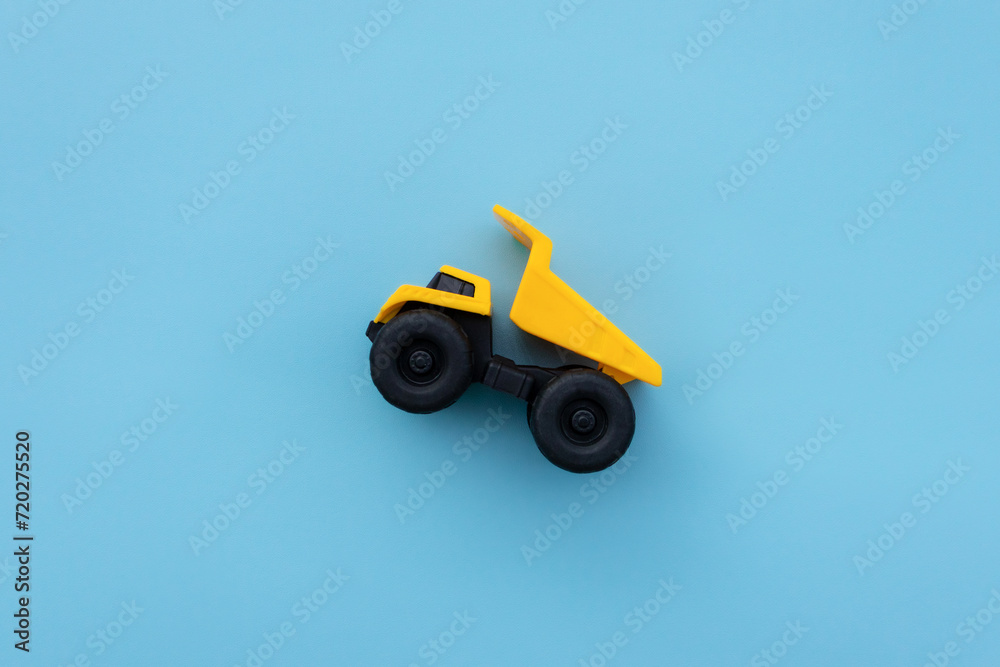 A dump truck miniature isolated on blue background. After some edits. A dump truck miniature isolated on blue background. After some edits.