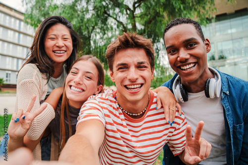 Group of multiracial young academic students smiling and taking a selfie together. Classmates looking at camera at university campus. Close up portrait of happy teenagers laughing and having fun. High photo