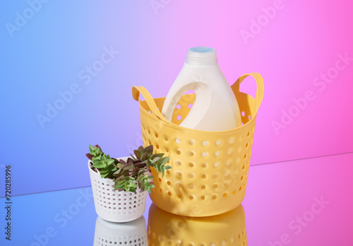 The laundry detergent stands in a yellow basket, the green plant.