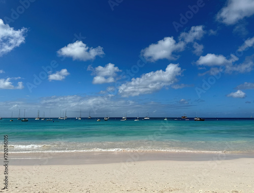 beach on caribben sea with many small boats and sailing boats photo