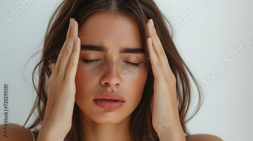 Beauty young woman clutching holding his head in worry with white studio background, worried stress headache depression concept