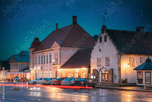 Kuressaare, Estonia. Old Gross Weight Storage Building House Near Market In Tallinna Street At Evening Night. Amazing Bold Bright Blue Starry Sky Gradient. Travel To Estonia. photo