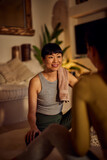 Photo of an Asian yoga instructor, talking to her client after the yoga class.