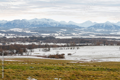 Winter landscape with Tatra mountains and villages in front of it.