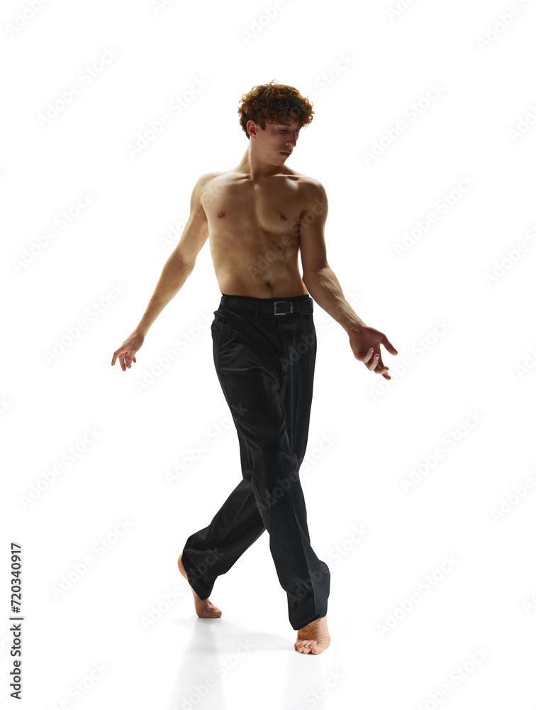 Subtle Intensity, dedication and inner strength. Young athlete man with naked torso posing against white studio background. Beauty and art, motion, action, flexibility, inspiration concept.