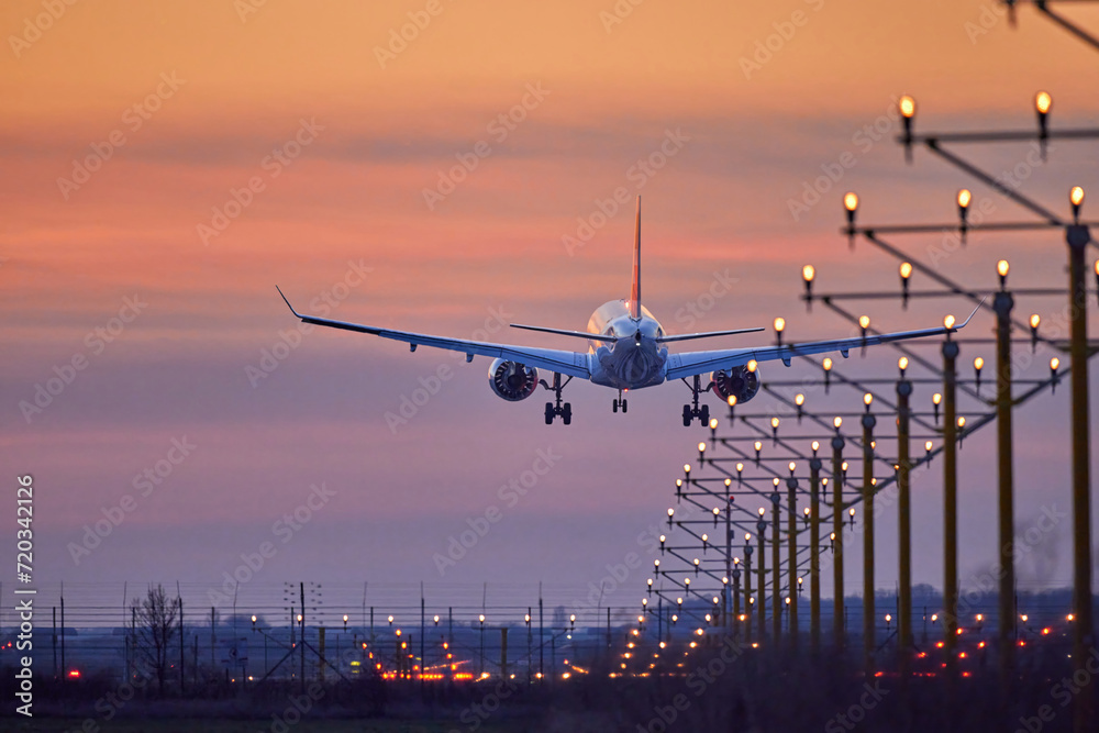 Passenger plane is landing during a wonderful sunset Passenger plane is landing during a wonderful sunset