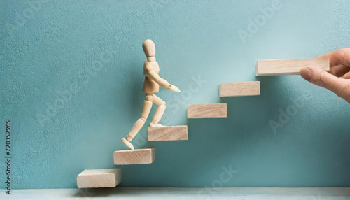 A figurine of a little man climbing the metaphorical ladder of progress, representing ambition and career growth