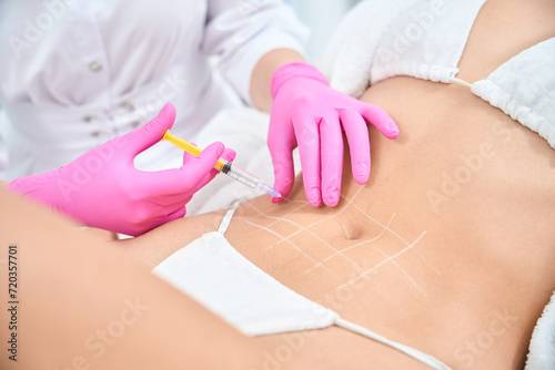 Beautician making beauty procedure for body to female