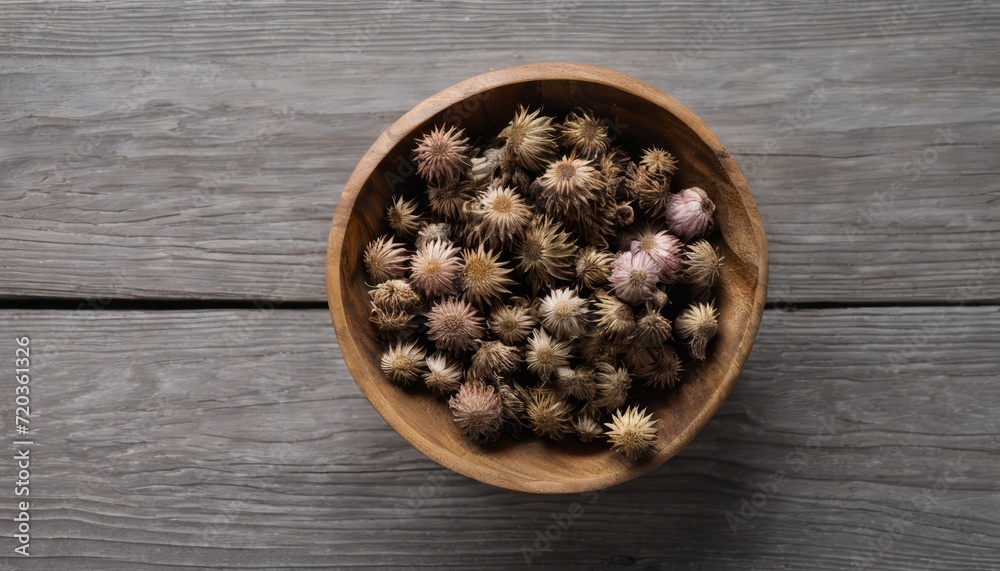 A wooden bowl filled with dried flowers A wooden bowl filled with dried flowers