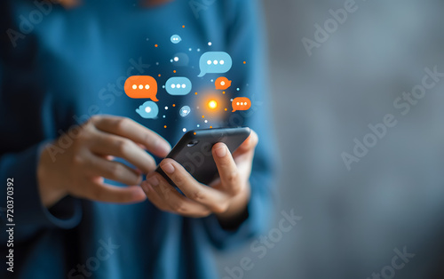 a person holds a smartphone with speech bubbles over it photo