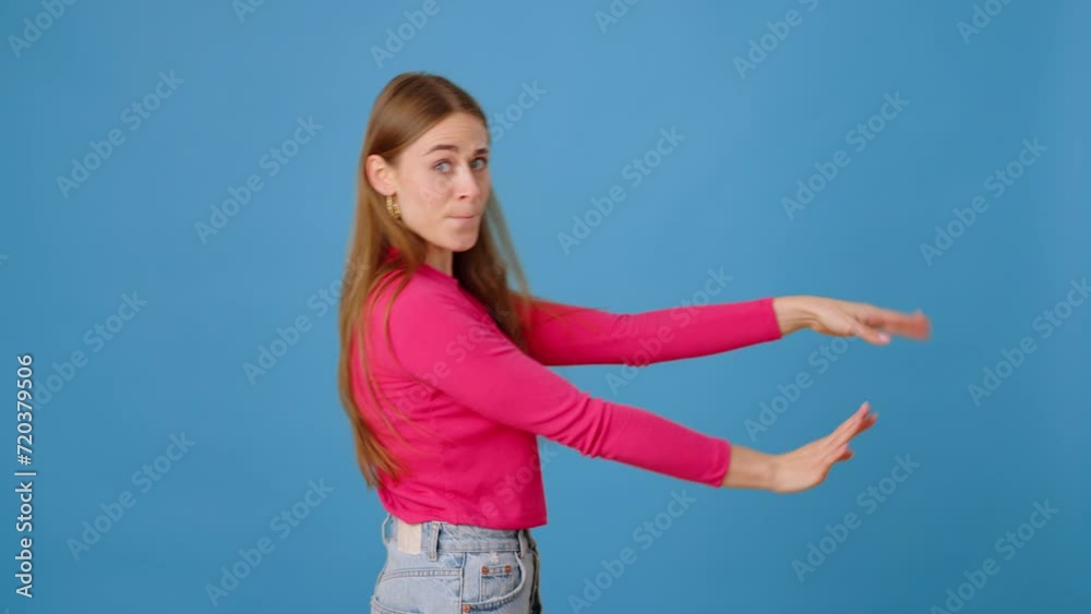 Joyful woman spinning in careless dance in blue studio Joyful woman spinning in careless dance in blue studio