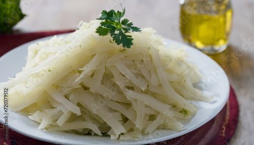 A plate of shredded potatoes with a sprig of parsley on top