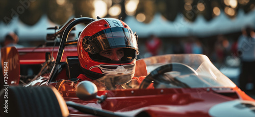 A formula pilot wearing a helmet sits in the car at the start of the race.