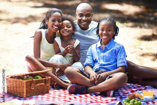 Portrait, happy and black family with forest picnic, fun or bonding in nature together. Love, food and children with parents in park for fruit, nutrition or healthy snacks while playing in the woods photo