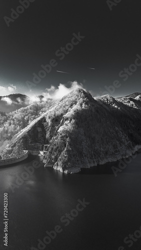 Beautiful mountain landscape in cold season. Black And White Winter landscape. Infrared photography. Mountain peak with a mountain lake covered with lichen. Frost forest on the mountain.  photo