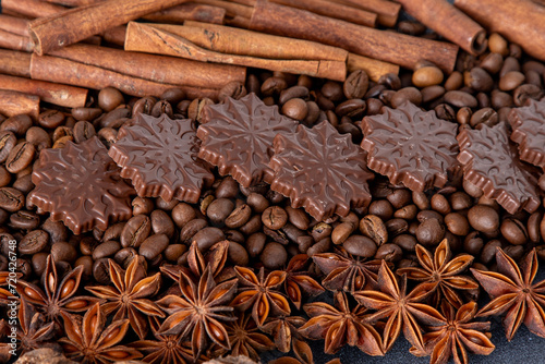 Food background. Coffee beans, cinnamon sticks, anise stars and chocolate candies top view.