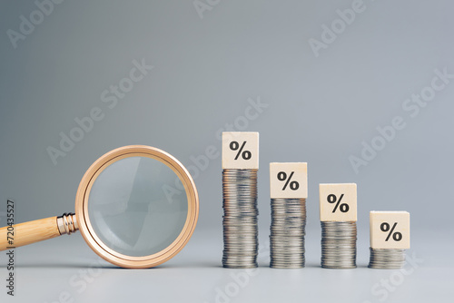 Decreasing money heaps with percentage icon, and magnifying glass, analysis, understanding, of percent, commission sales, debt, business and finance