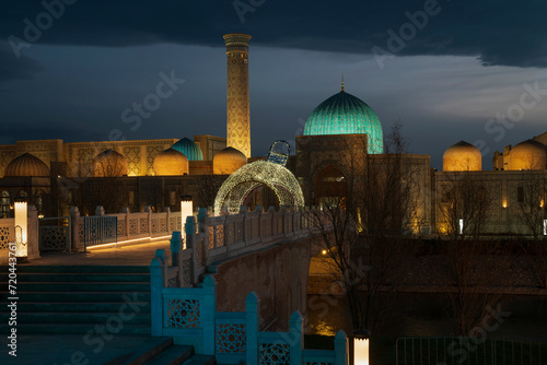 View of the historical and ethnographic complex "Eternal City" with night illumination against the sunset sky, Samarkand, Uzbekistan