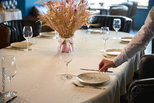 Canvas Print Close up of waitress lays out cutlery