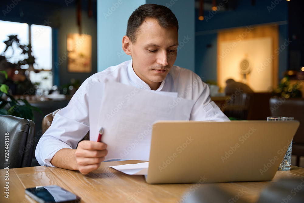 Kitchen employee works with documents