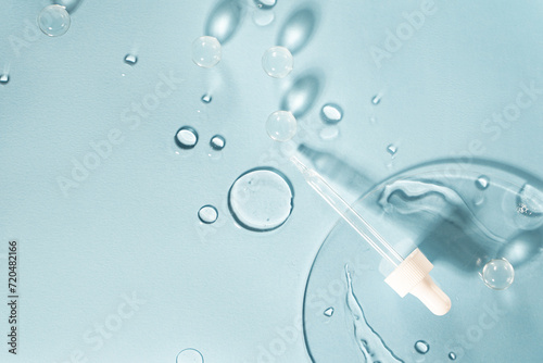 Drug development. Skin care cosmetics. Medical pipette on a blue background. The liquid essence flows