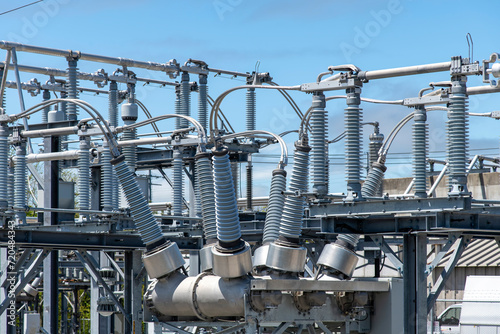 Close up view of some high-voltage bushings on a utility transformer at an electrical substation which allows an electrical conductor to pass safely through a conducting barrier