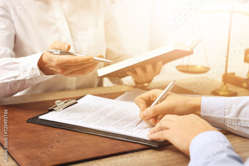 Lawyer working with client at wooden table in office, closeup