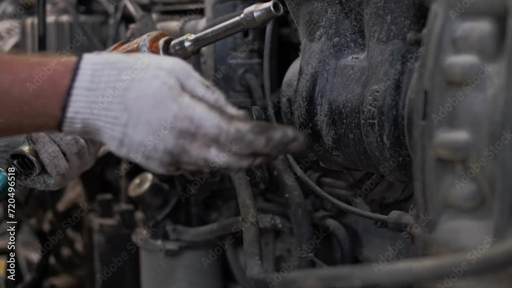 Reassembly after repair of a cargo engine using a pneumatic wrench at a cargo van service station. Close-up Reassembly after repair of a cargo engine using a pneumatic wrench at a cargo van service station. Close-up