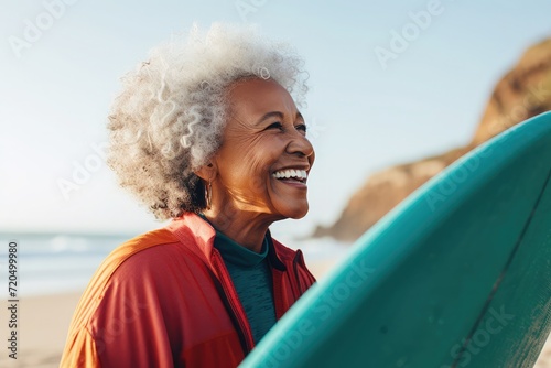 Side view, a happy 79-year-old black woman, with surfboard, at beach, teal clothes ,