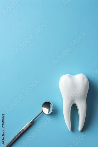 Vertical image of a blue postcard with a white fake tooth, concept of dentistry, dental care and international dentist day celebration © Sunny