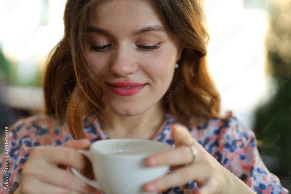 Attractive young woman enjoys a morning cup of coffee, capturing the essence of a cozy and delightful atmosphere.
