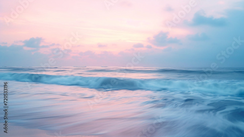 A calm beach yoga session at dusk soft pastel colors in the sky and gentle waves. © Carlos