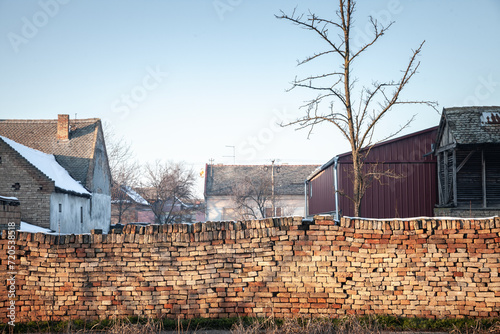 Picture of a decaying wall made of red bricks in an half abandoned village of serbia in the norther province of vojvodina. photo
