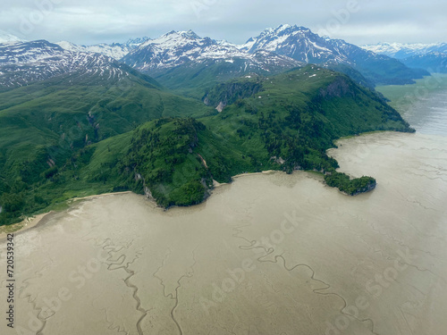 Tuxedni Bay on Cook Inlet at Lake Clark National Park in Alaska. Aerial view of estuary, tidal flats or mud flats, salt water marshes, and Chingmit mountains. Native owned fishing camp.  photo