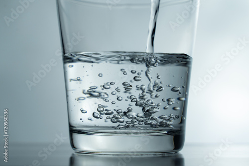 close-up Filling a glass with water showing a drink concept. bubbles in fresh water with white background. 
