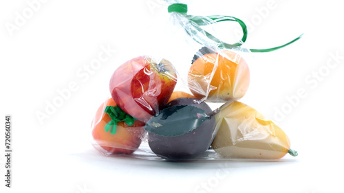 closeup of a bag of various marzipan fruit on white background