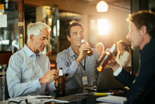 Businessmen drinking after work at a bar photo