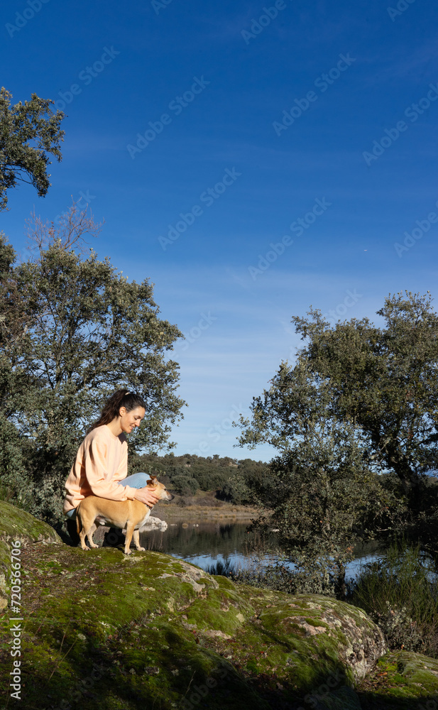 Woman sitting with her dog in nature