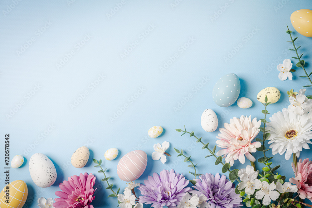 Colorful Easter eggs and spring flowers on light blue background, flat lay. Space for text Colorful Easter eggs and spring flowers on light blue background, flat lay. Space for text