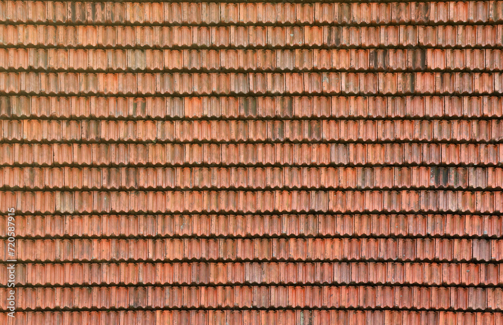 Close up of red terracotta roof shingles with some mildew. Background texture of old roofing material Close up of red terracotta roof shingles with some mildew. Background texture of old roofing material