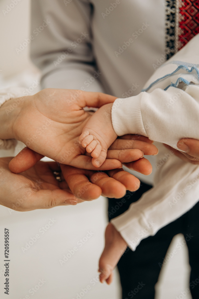 Obraz premium A close-up photo of a small child's leg in his hands. Touching the child's toes. A child's sleep