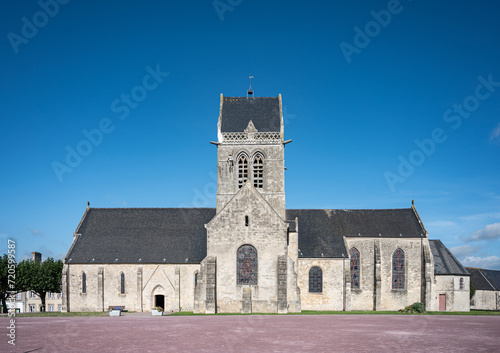 Vászonkép Detail of the pretty old church of Sainte Mere Eglise with the airborne military