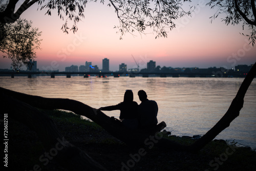 silhouette of a couple sitting on a pier in Boston 