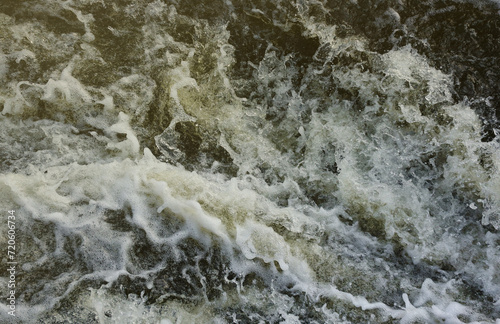 Waves of water of the river and the sea meet each other during high tide and low tide. Deep blue stormy sea water surface with white foam and waves pattern, background photo texture