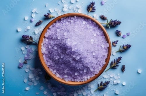 purple sea salt in cup with lavender on blue background. product for skin care and bath procedures.
