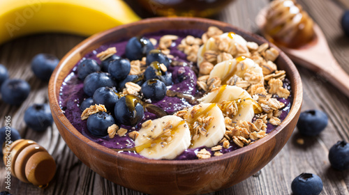 A refreshing acai bowl topped with sliced bananas blueberries granola and a drizzle of honey perfect for a healthy snack.
